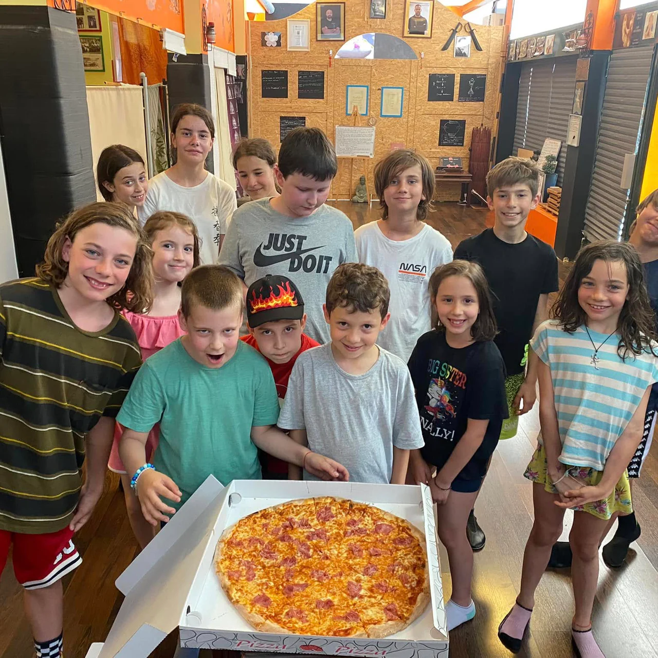 I bambini attorno a una pizza, alla festa di fine corso