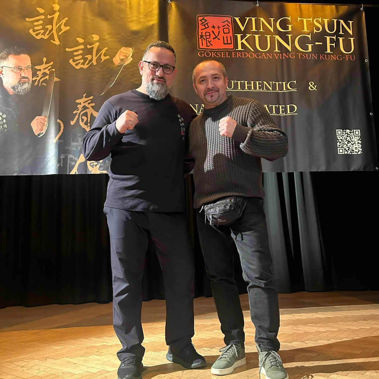 Sifu Luca Bomba con un maestro davanti allo striscione Ving Tsun Kung-Fu